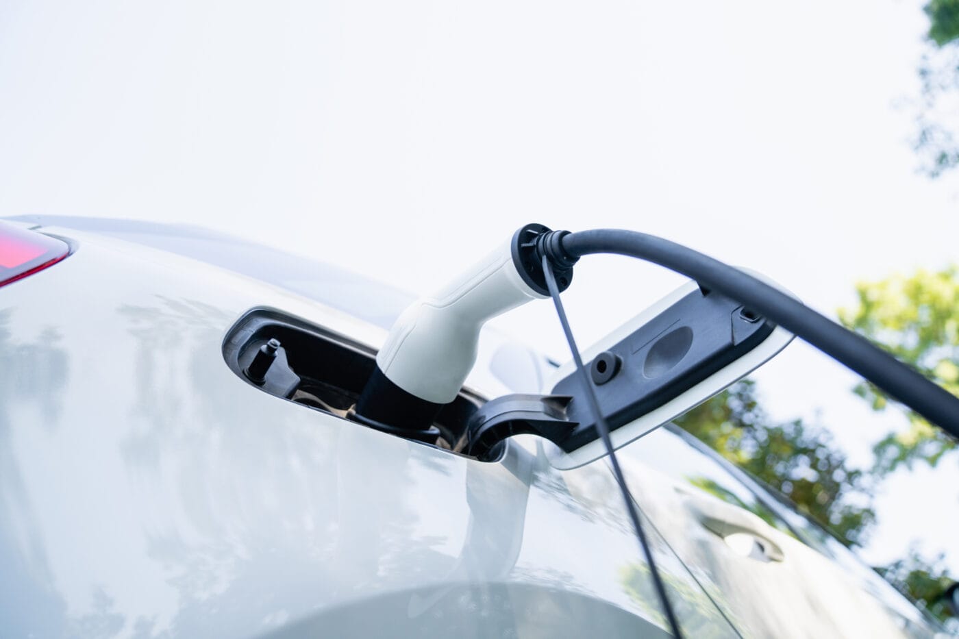 Close up of electric car inlet with a connected charging cable