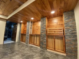 Room with wood and stone accents, recessed lighting, and built-in shelves against the wall.